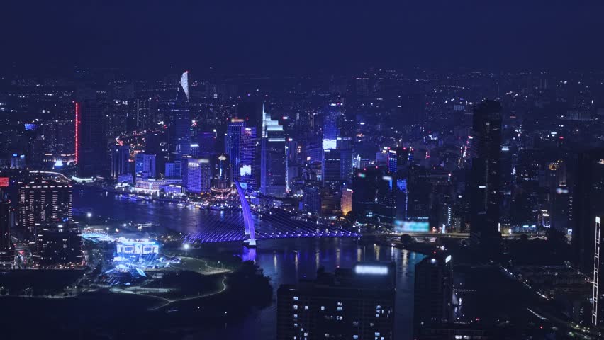Aerial night view Ho chi minh city and Saigon river in Vietnam, illuminated of bridge and business center with skyscrapers.