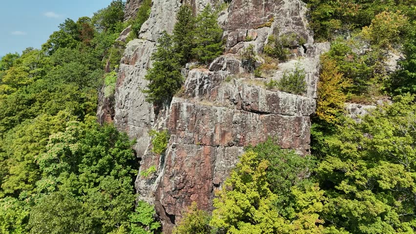 Drone view of Castle Craig atop East Peak in Hubbard Park, Meriden, CT. Historic stone tower surrounded by forest, scenic hills, and panoramic New England landscape.