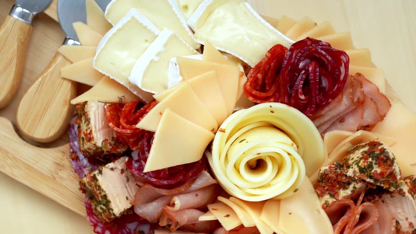 Food trend gift aperitivo party idea. Appetizers wooden grazing board with different antipasti charcuterie snacks and cheese. Assorted cheese meat platter. Disordered eating