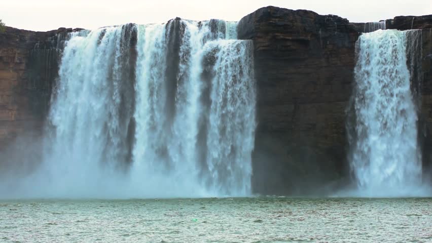 Slow-motion video capturing the serene beauty of Chitrakote waterfalls in Bastar, India, at sunrise, highlighting golden light, mist, and spiritual tranquility.