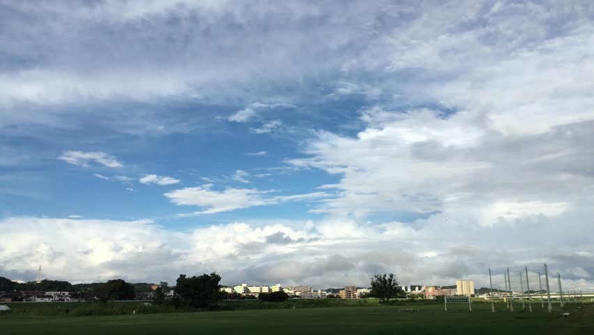 Green meadow landscape near Tokyo, blue sky with fluffy clouds, serene scenery
