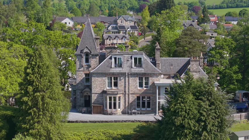 Revealing the top roof of a mansion house in Pitlochry, Scotland, showcasing its historic architecture and surrounding scenic highland landscapes