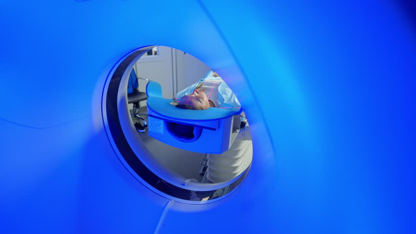 Female Patient Lying on a CT or MRI Scan, Bed is Moving Inside the Machine In Medical Laboratory or Healthcare Facility with High-Tech Equipment. Video computed tomography CT scan process for - Powered by Shutterstock - Get 15% off with code: PIKWIZARD15