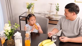 A father and daughter share a joyful breakfast in a bright, cozy dining room, fostering family bonding and happiness - Powered by Shutterstock - Get 15% off with code: PIKWIZARD15