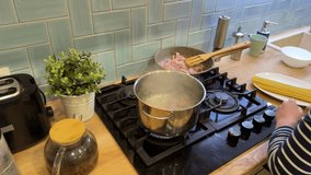 A handsome boy is preparing a rich carbonara sauce for his pasta dish in the kitchen. - Powered by Shutterstock - Get 15% off with code: PIKWIZARD15