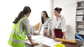 Professional female architect collaborating with businesswomen, discussing building models and blueprints on an office desk, highlighting engineering expertise and project planning - Powered by Shutterstock - Get 15% off with code: PIKWIZARD15