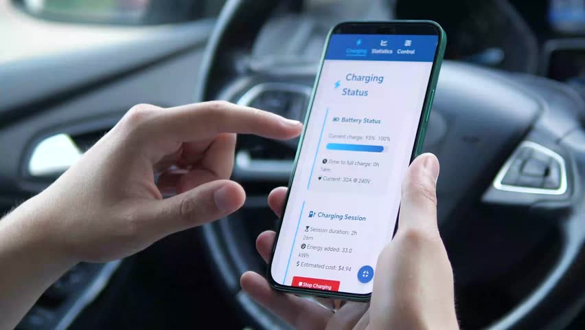 Close-up of a driver's hands in a car using a dedicated mobile application to manage an electric vehicle charging session. He navigates the interface, reviews real-time charging data, and initiates - Powered by Shutterstock - Get 15% off with code: PIKWIZARD15