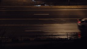 Cars glide along a rain-soaked road at night, street lamps reflecting on the wet pavement and casting a moody, cinematic glow over the scene. - Powered by Shutterstock - Get 15% off with code: PIKWIZARD15