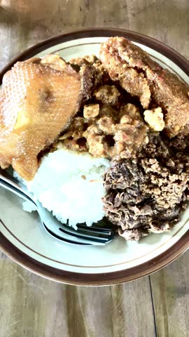 A plate of gudeg rice, krecek, and chicken at Soto and Gudeg Pak Muh in Kalasan Central Java, taken 19 February 2025.

