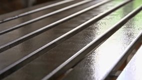 A close-up shot shows the process of a row of wooden planks being spray-painted with a wet, glossy finish, highlighting the painting and varnishing process in a furniture factory. - Powered by Shutterstock - Get 15% off with code: PIKWIZARD15