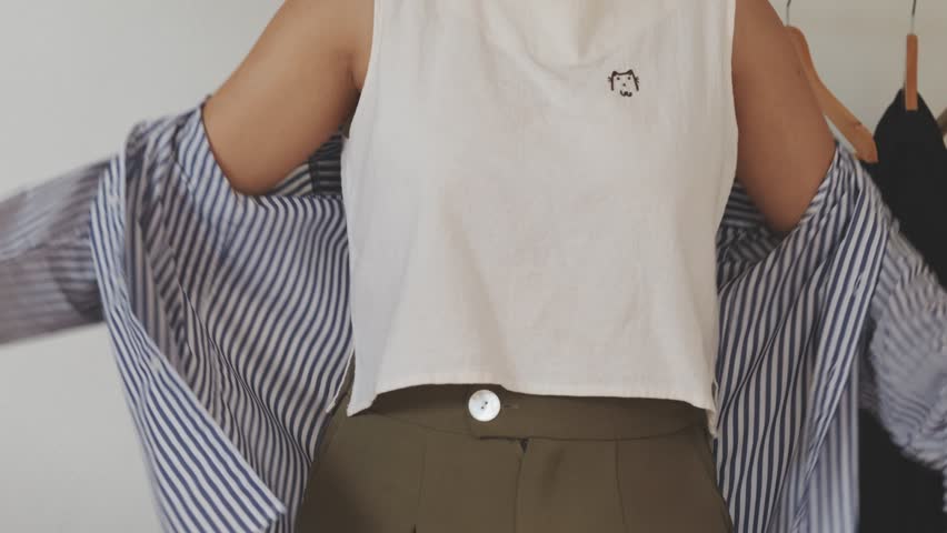 Woman  getting clothes and adjusting black jacket.