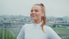 A Confident Woman in Activewear Enjoying the Outdoors with a Look of Determination and Contentment Against a Cityscape Background - Powered by Shutterstock - Get 15% off with code: PIKWIZARD15