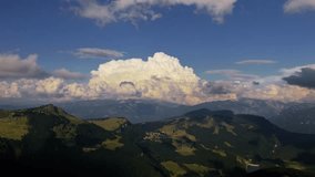 Massive cumulus clouds building above Monte Baldo and Lake Garda area in the Italian Alps, drone moving forward over green mountain slopes and valleys - Powered by Shutterstock - Get 15% off with code: PIKWIZARD15