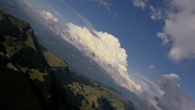 Drone flying forward with roll to the right over Monte Baldo slopes under giant cumulus cloud, Italian Alps - Powered by Shutterstock - Get 15% off with code: PIKWIZARD15