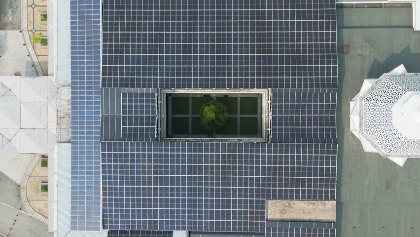 Top-down drone shot of a tree in the middle of Raja Haji Fisabilillah Mosque (Cyberjaya Mosque) with solar panels during the day in Cyberjaya, Sepang, Selangor, Malaysia