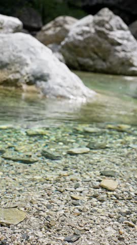 A serene natural pool with crystal clear water and large stones, perfect for relaxation and nature lovers. Slow motion