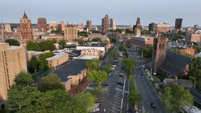 Aerial view of downtown New Haven, Connecticut, showing historic churches, Yale University buildings and modern skyscrapers in warm evening light. Waving American flag in proud city. Wide shot. - Powered by Shutterstock - Get 15% off with code: PIKWIZARD15