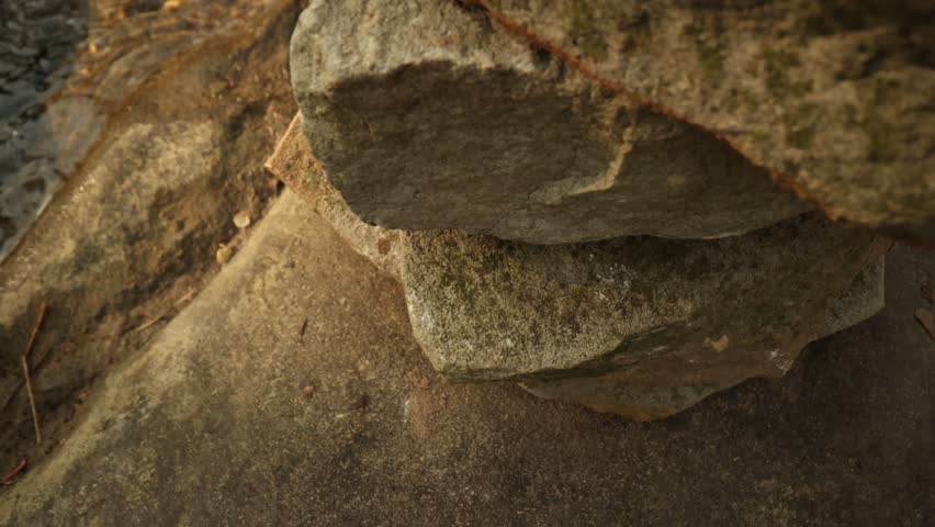 Slow Rise Up View Over Stacked Rocks Near River
