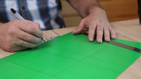 Hands drawing cutting lines on colored cardboard, crafting template for paper model, DIY project preparation. - Powered by Shutterstock - Get 15% off with code: PIKWIZARD15