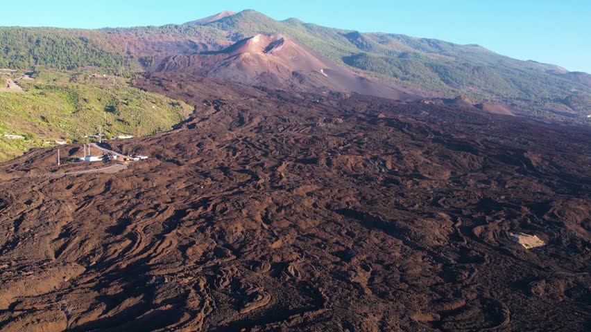 Aerial lava and crater of Cumbre Vieja volcano two years after eruption with houses of small town on La Palma island Canary Islands Spain