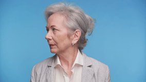 Confident Senior Woman in Business Attire on Blue Background - Powered by Shutterstock - Get 15% off with code: PIKWIZARD15