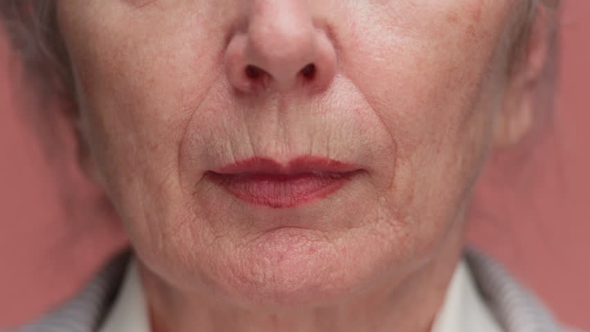 Close up of senior woman mouth and chin on pink