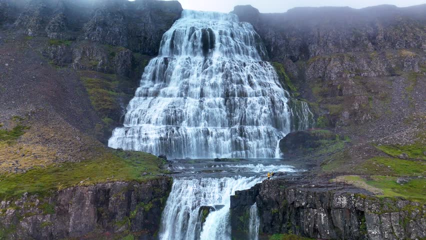 Witness the majestic Dynjandi waterfall in Iceland as it flows gracefully down the mountainside.