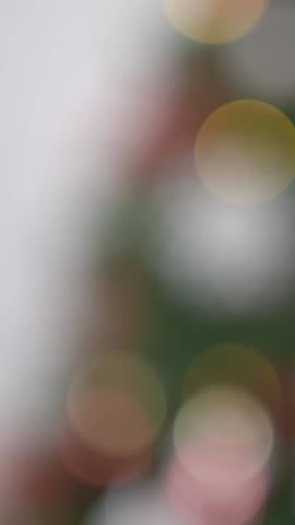 Vertical Adorned with holiday white snowflake, a festive Christmas white snow flake hang on the tree lush green branches, creating a beautiful Xmas decoration.