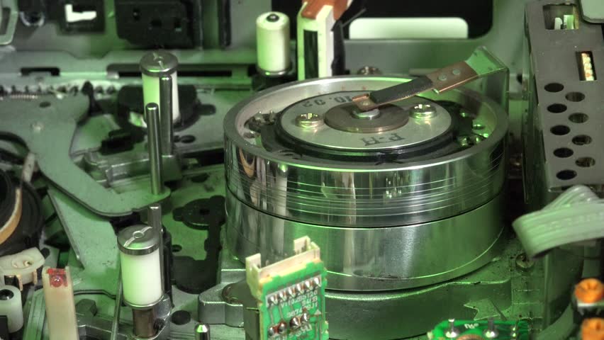 Close-Up of VHS Player Mechanism Showing Tape and Internal Components, in load and play movements, with colored light effects