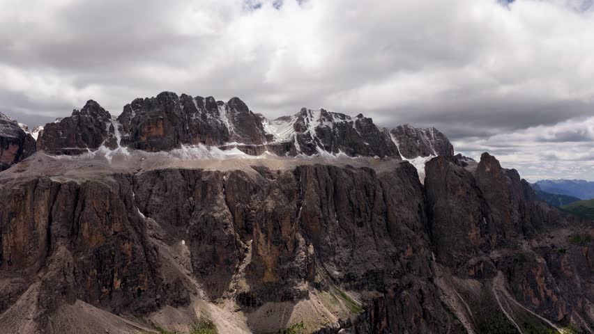 Epic Drone Reveal of the Sella Group Towering Cliffs with Late Snow on Rugged Dolomite Peaks