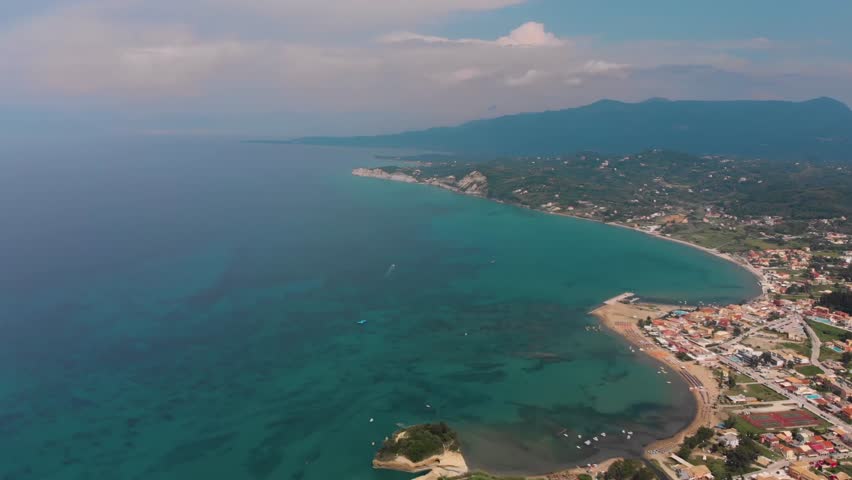 Drone footage captures the stunning aerial perspective of Sidari, Corfu, Greece, showcasing the famous Canal D'Amour rock formations and the beautiful sandy beaches bathed in turquoise Ionian Sea wate