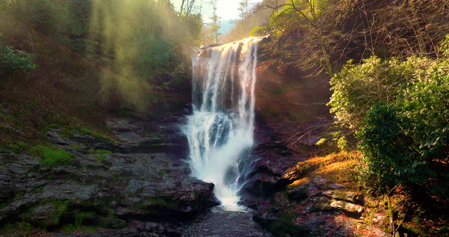 Dry Falls in western North Carolina with clear water cascading through colorful autumn forest. Scenic view along the Mountain Waters Scenic Byway