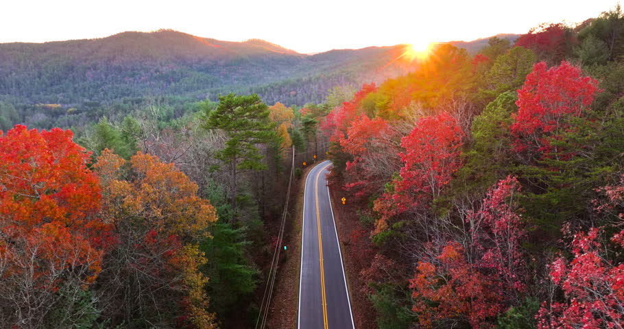 Blue Ridge Parkway at sunset in autumn. Scenic route between majestic mountain hills covered in golden and scarlet leaves