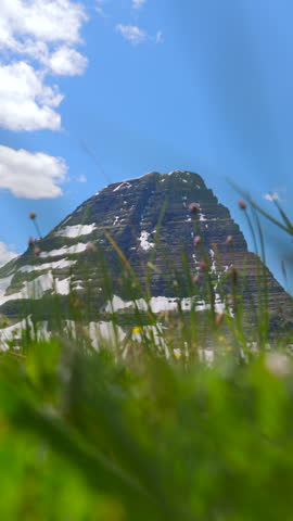 Explore the breathtaking landscapes of Glacier National Park in Montana, featuring impressive mountains, vibrant greenery, and stunning blue skies that will leave you in awe on your outdoor adventure