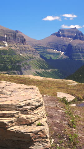 Male hiker at his break with breathtaking and stunning landscapes of Glacier National Park, located in beautiful Montana, where you explore amazing mountain vistas and indulge in outdoor adventures