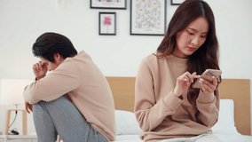 Asian couple on bed with digital disconnect causes relationship conflict, upset and worried, smartphone addiction strains romantic relationship, problem and unhappy, stress and trouble of couple. - Powered by Shutterstock - Get 15% off with code: PIKWIZARD15