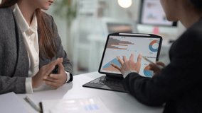 Two women are looking at a computer screen with graphs on it. They are discussing the data and making decisions based on the information. Scene is serious and focused - Powered by Shutterstock - Get 15% off with code: PIKWIZARD15