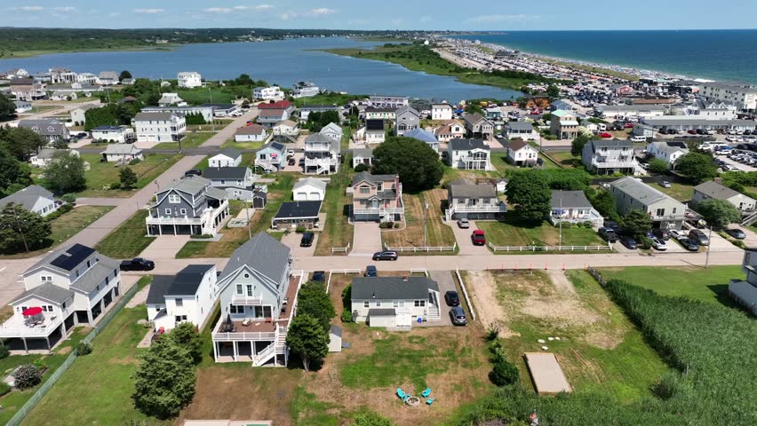Houses and homes with solar panels in Misquamicut, Rhode Island.sunny summer day with winnapaug pond and ocean water. Luxury buildings near beach. drone flyover shot.