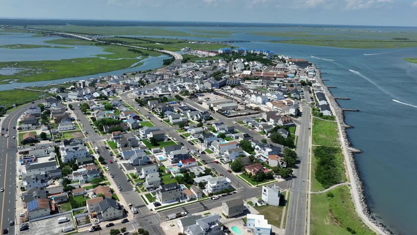City of wildwood in New Jersey surrounded by water channel and river between wetland. Aerial wide shot. Sunny day in America. Noble beach houses and villas at Atlantic Ocean.