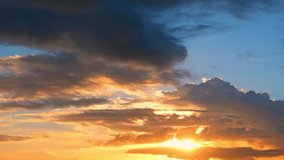 A sunset timelapse captures golden light breaking through dark clouds, painting the sky in fiery orange and soft blue tones, reflecting the shifting beauty of evening weather in nature’s cycle.
 - Powered by Shutterstock - Get 15% off with code: PIKWIZARD15