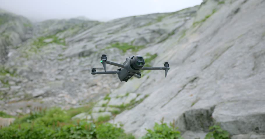 DJI Mavic 3 Pro drone flying with rocky mountain landscape in background