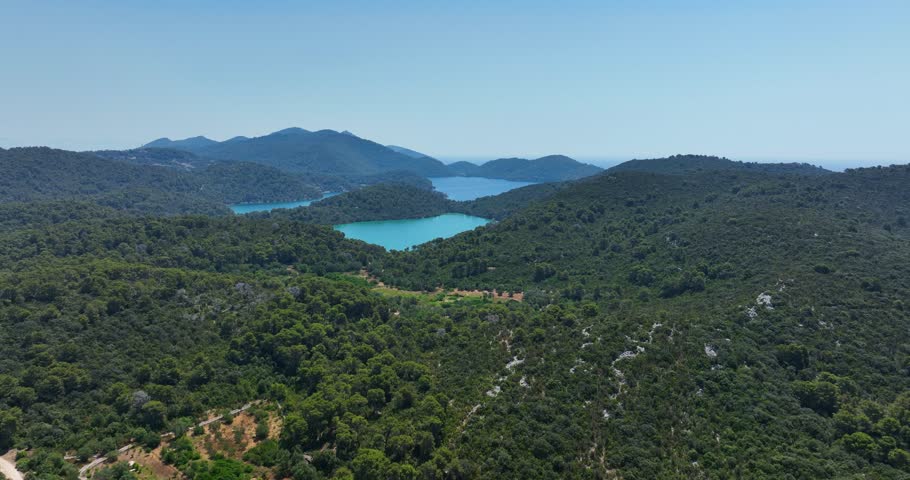 Panoramic aerial shot of forested mountains and turquoise lakes in Mljet National Park, Croatia