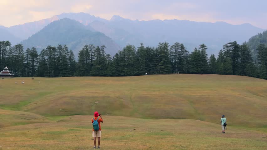 Two happy male friends spending leisure time and lying down in a green grass at park in Tirthan Valley, Shangarh himanchal pradesh india.	