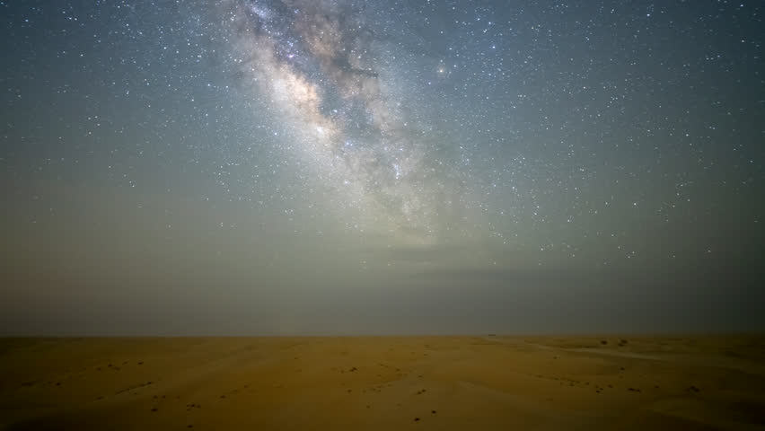 Stunning 4k timelapse of the night sky Milky Way galaxy motion over camping in the desert sand dune. Clear night sky, stars scape in a remote wilderness location. 