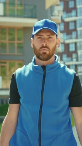A delivery man in blue navigates the urban landscape with boxes