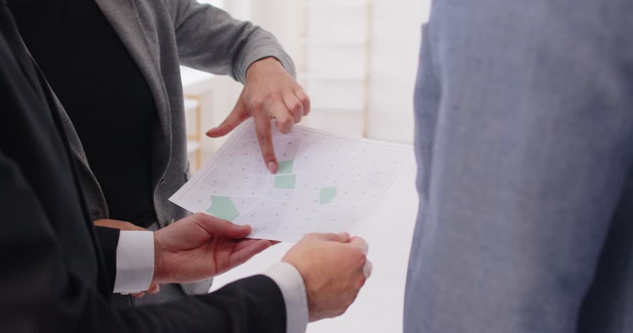 Business meeting for discussion of urban construction project by expert and investors. Architect holding paper land map to discuss and talk, showing paper document to explain and plan blueprint
