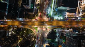Aerial timelapse of busy intersection in Bangkok, Thailand, showing heavy traffic, illuminated streets, and city buildings at night. Vibrant urban scene with dynamic motion and colors. - Powered by Shutterstock - Get 15% off with code: PIKWIZARD15