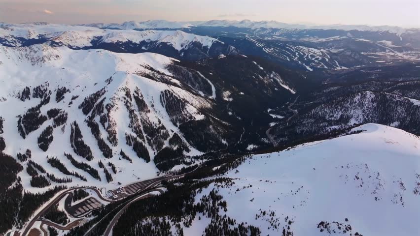 Winter Spring Arapahoe Basin Abay Ski Resort sunset golden hour Loveland Pass Colorado aerial drone view Continental Divide Keystone Breckenridge ski trail runs windy road parking lot backwards pan up