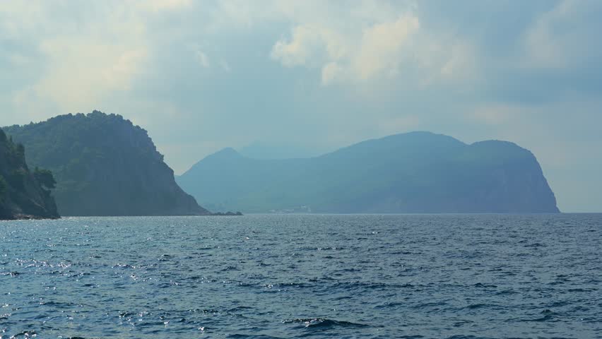 beautiful and dramatic seascape with view of cliffы covered with forest and storm clouds above it, stormy sky
