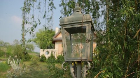 Old wooden lamp, weeping willow, and country cottage